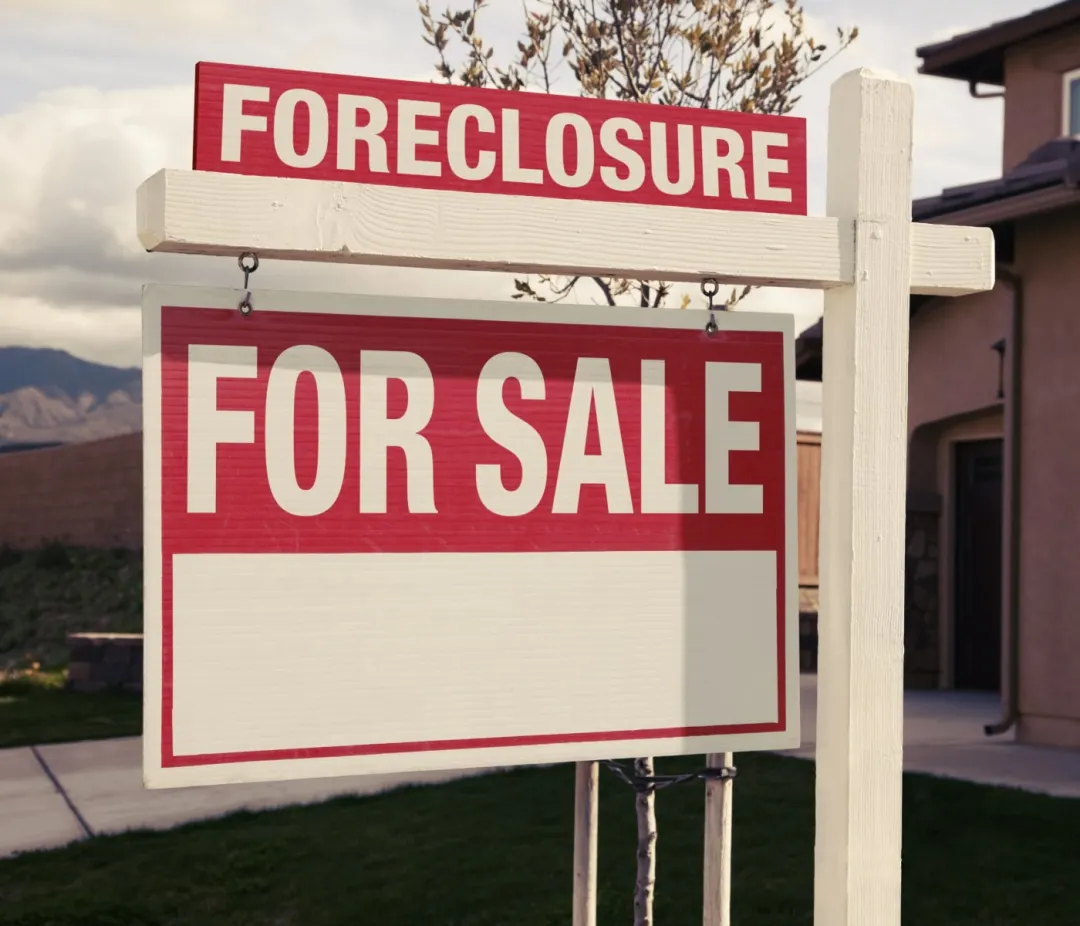 Foreclosure for sale sign in front of a house